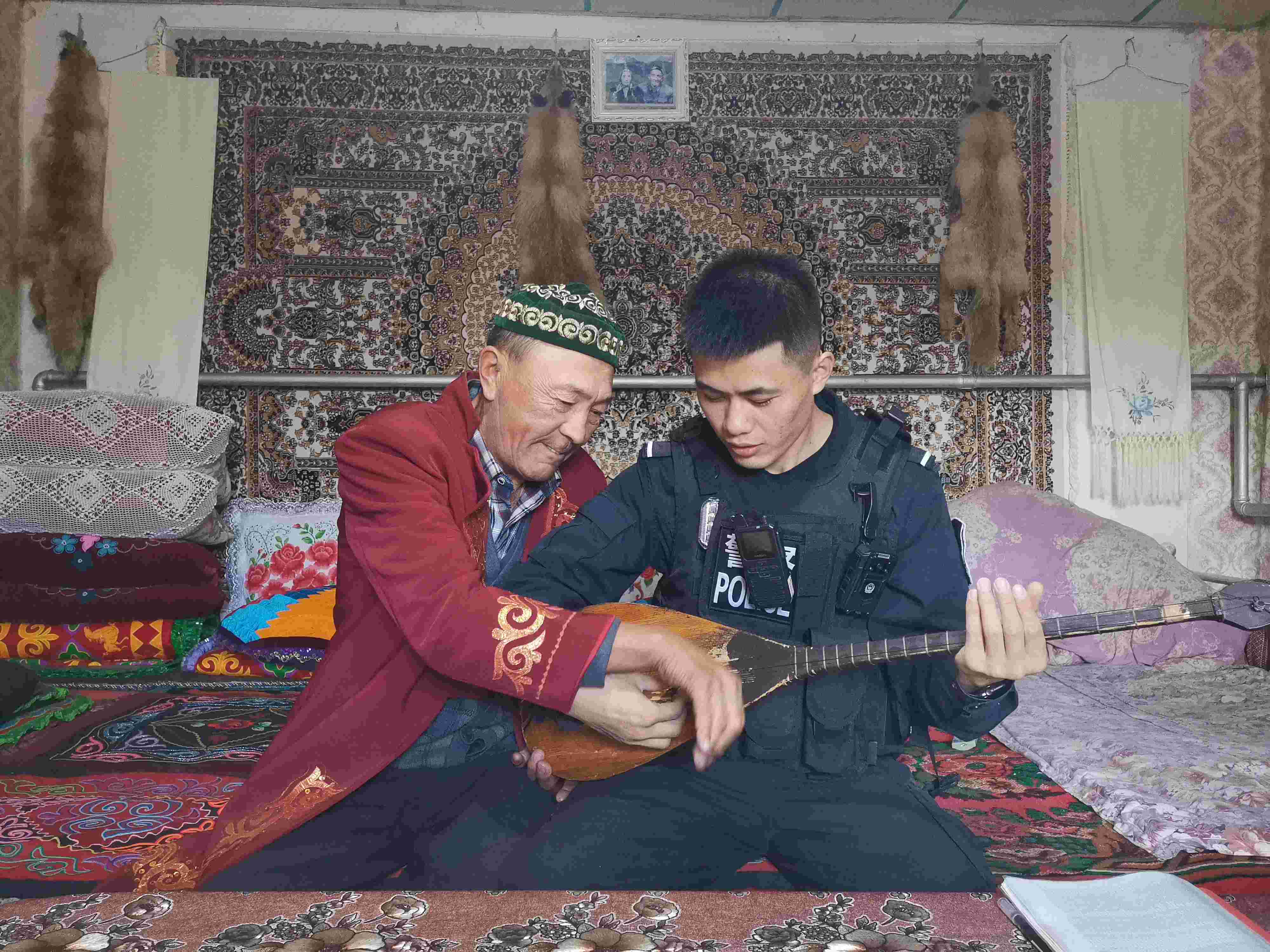 老人手把手交边境民警学习民族乐器.jpg 老人手把手交边境民警学习民族乐器.jpg