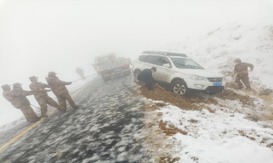 霍尔果斯民警和护边员雪天暖心救助被困车辆