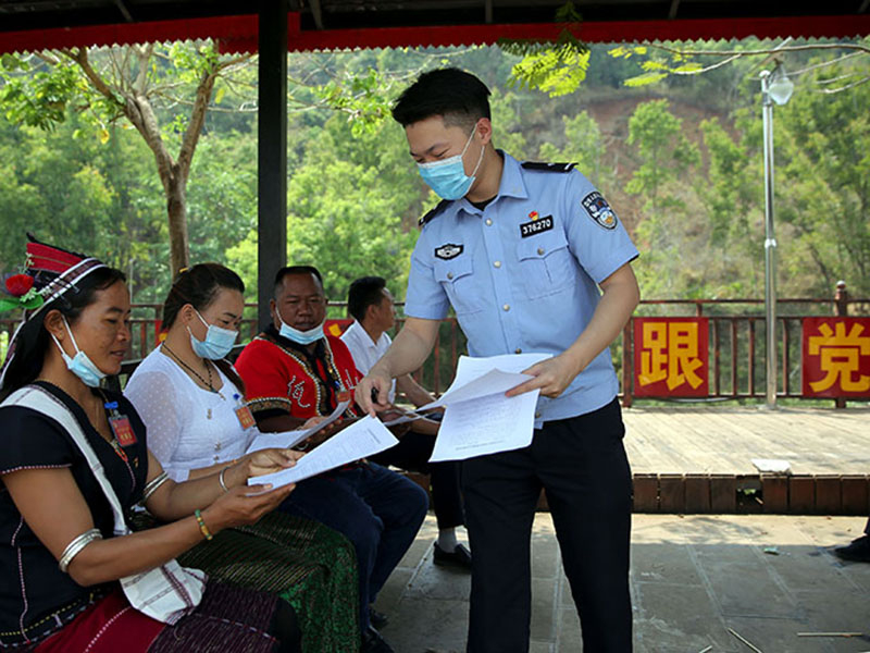 图为普洱边境管理支队民警向佤族群众收集普法需求.jpg
