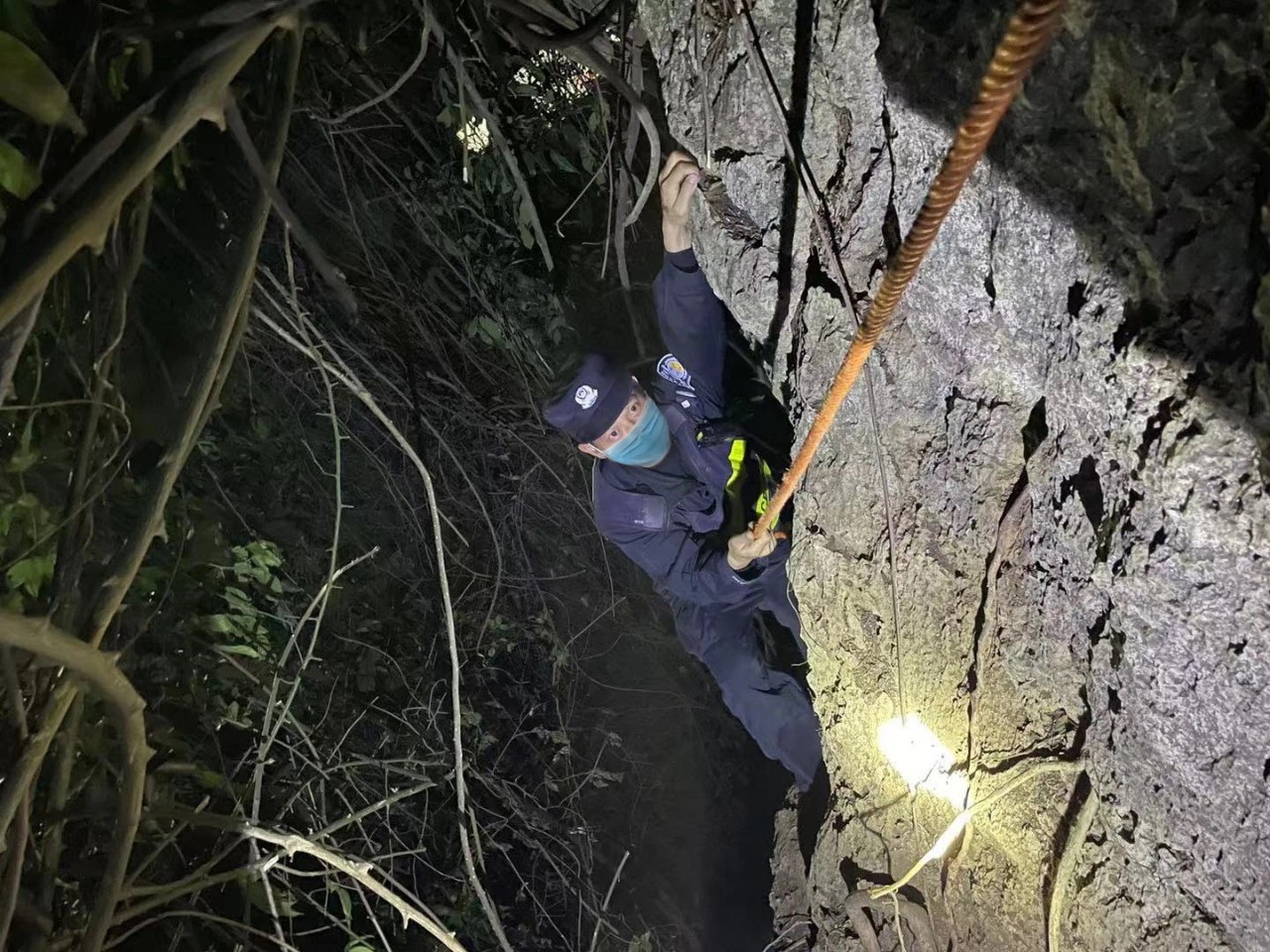 图为广西友谊关出入境边防检查站弄尧分站民警夜间前往执勤点,用绳子攀爬陡崖 王建功摄.jpg 图为广西友谊关出入境边防检查站弄尧分站民警夜间前往执勤点,用绳子攀爬陡崖 王建功摄.jpg