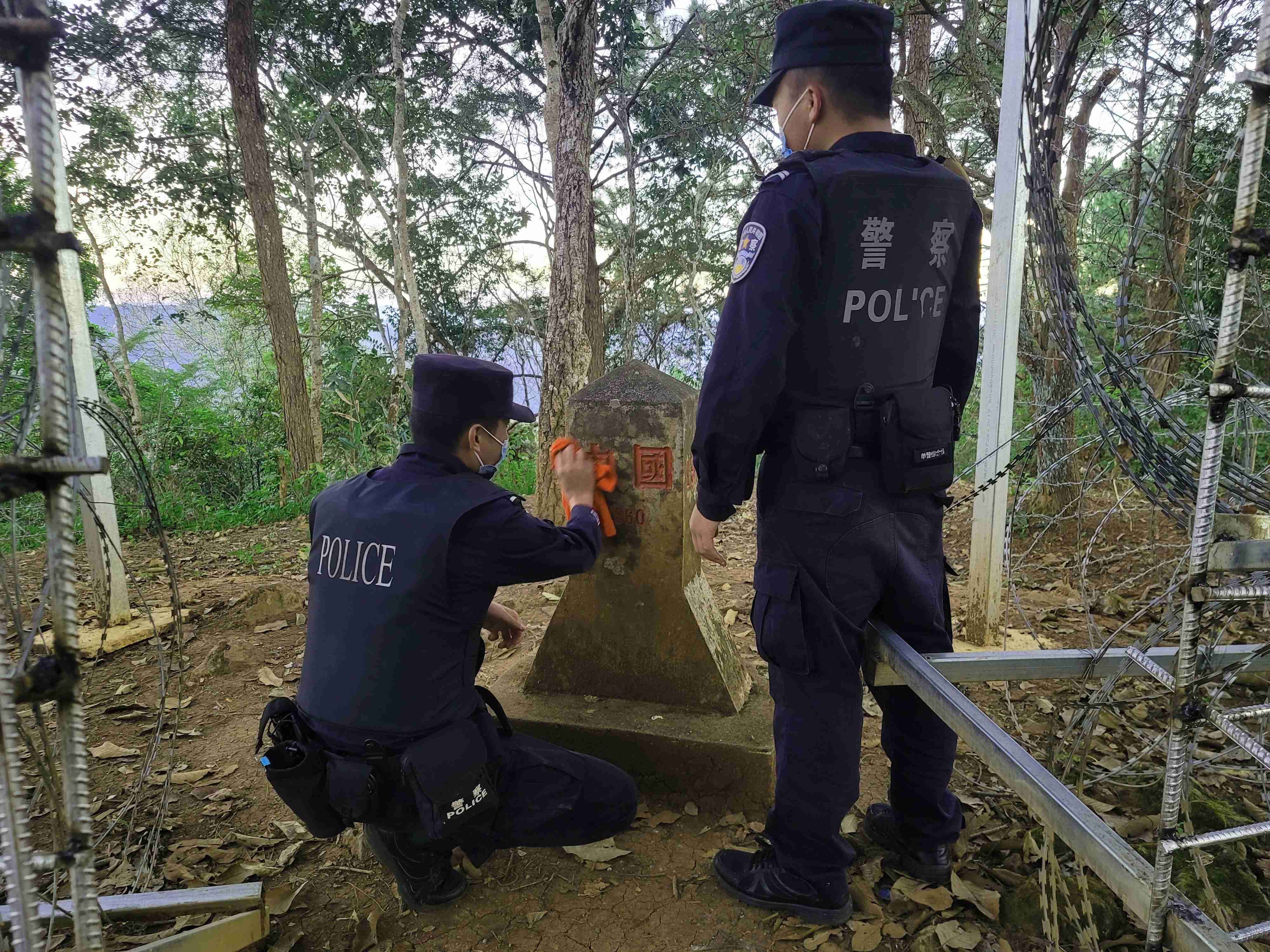 图为师徒民警正在擦拭界碑(1).jpg