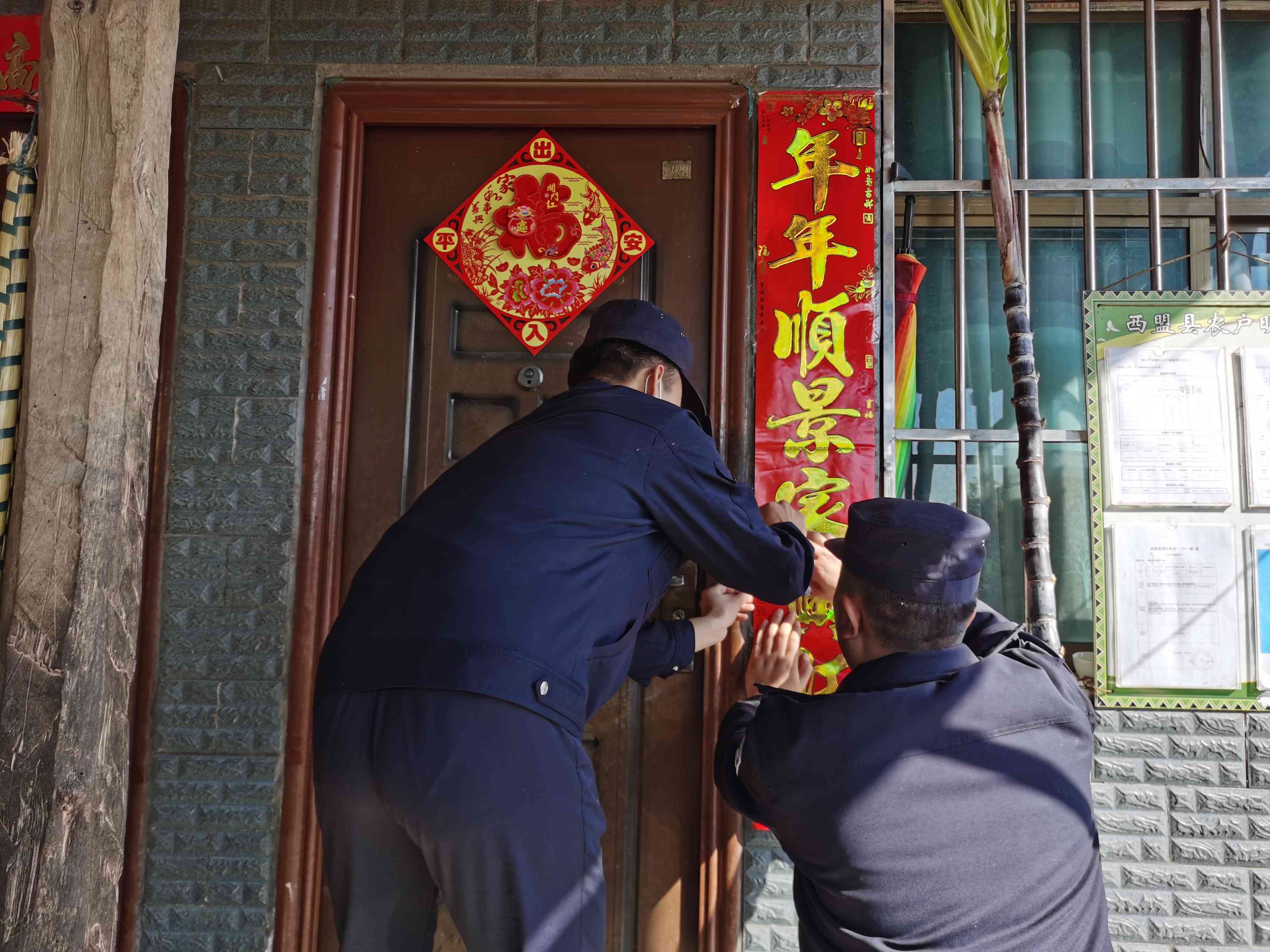 图为西盟大队民警为群众贴春联.jpg