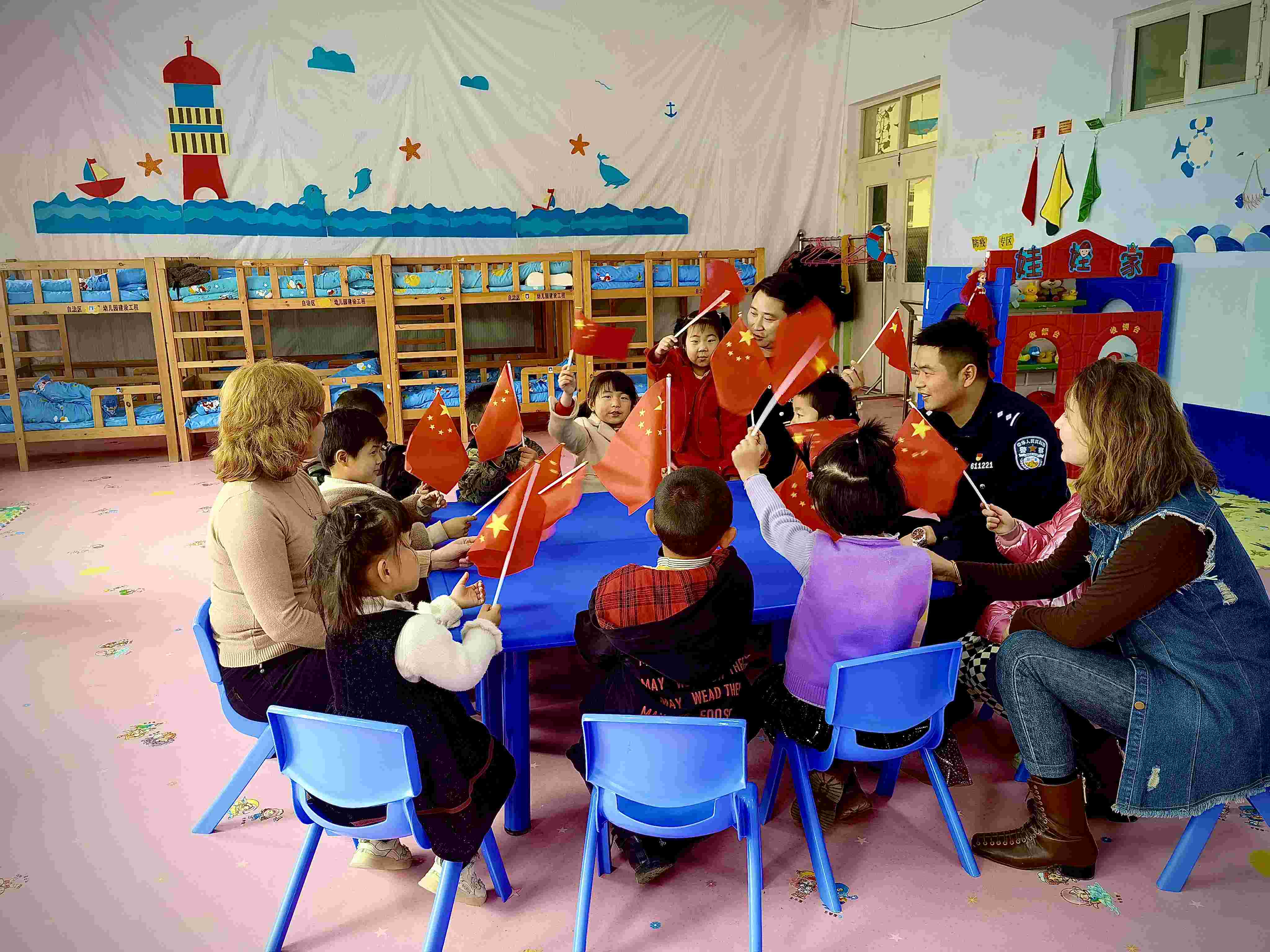 图为”颗颗想拥“民族团结情活动现场 民警向孩子们讲述新疆史.jpg