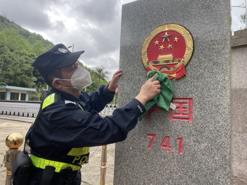 民警为界碑清洁.jpg