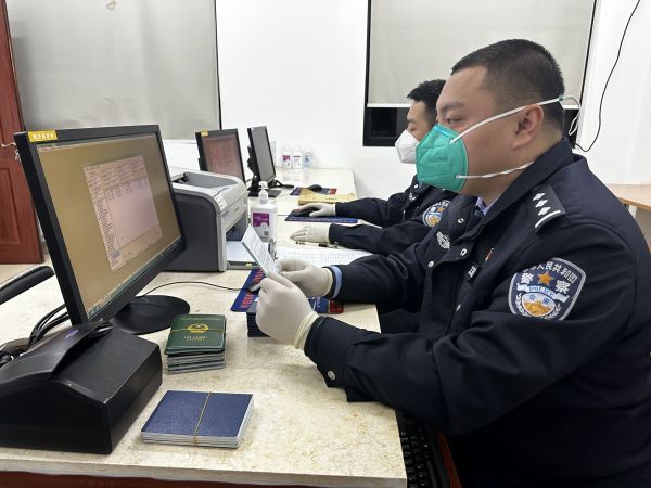洋2 图为执勤民警正在查验出入境船舶的船员证件.jpg