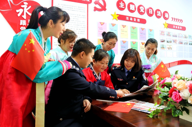图为民警与朝鲜族群众读报学习两会精神_副本.jpg