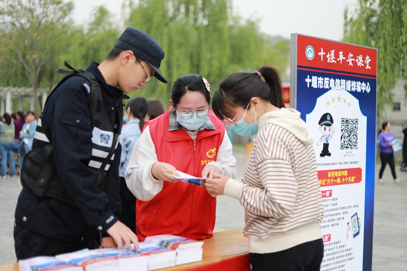 在十堰市郧阳区白浪镇文明实践活动现场,志愿者向群众宣讲反电诈知识.jpg 在十堰市郧阳区白浪镇文明实践活动现场,志愿者向群众宣讲反电诈知识.jpg