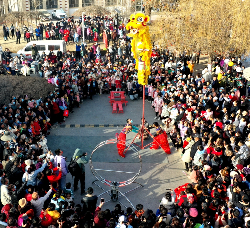 新疆生产建设兵团第一师十团职工群众在居民区欣赏传统文化节目表演 王志清摄.jpg