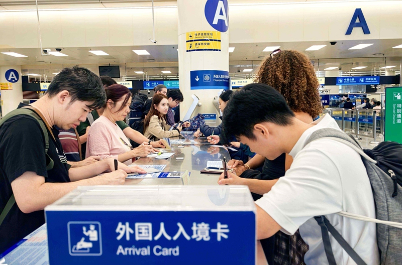 不少赴广州参加广交会的外籍商客在福田口岸填写入境卡.jpg 不少赴广州参加广交会的外籍商客在福田口岸填写入境卡.jpg