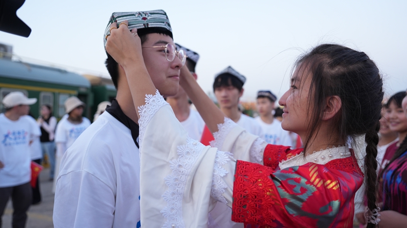 阿拉尔学生为台州学子戴上维吾尔族小花帽。卿朋 摄.jpg