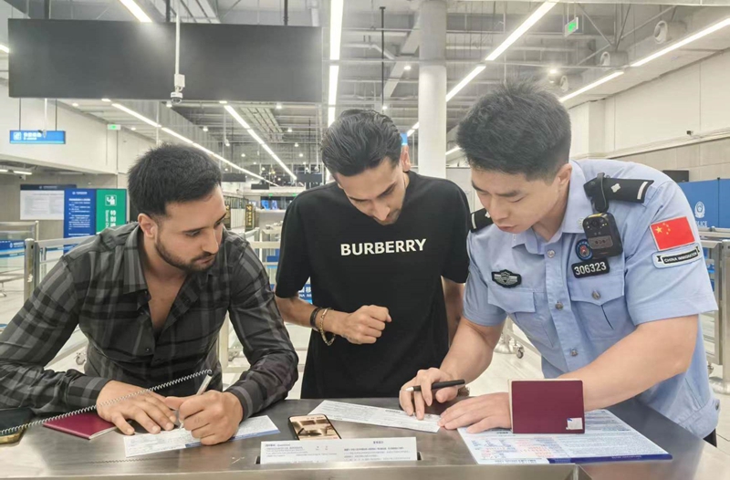 皇岗边检站移民管理警察帮助参加广交会的德国商客填写入境卡.jpg 皇岗边检站移民管理警察帮助参加广交会的德国商客填写入境卡.jpg