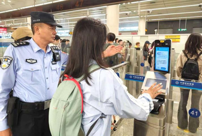 皇岗边检站民警黄国春在福田口岸出境大厅引导旅客正确刷脸通关.jpg 皇岗边检站民警黄国春在福田口岸出境大厅引导旅客正确刷脸通关.jpg