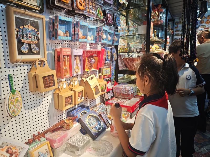 在新疆生产建设兵团第十二师“恋疆记新疆礼物”文创优品店，各类文创产品琳琅满目，顾客正在挑选。摄影  冯晓玲.jpg