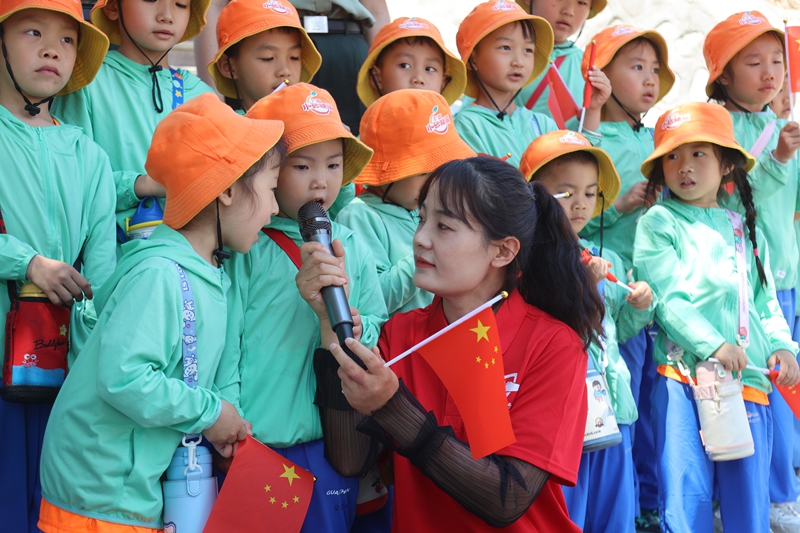 广西“小砂糖橘”研学团小朋友在新疆生产建设兵团第九师白杨市小白杨文化旅游区同唱《小白杨》。  冯小青摄.jpg