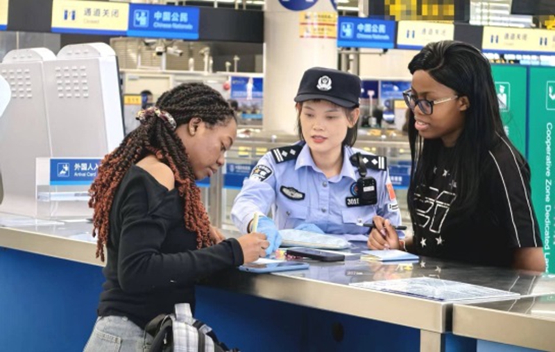 皇岗边检站民警引导经福田口岸入境参加高交会的外国商客填写入境卡.jpg 皇岗边检站民警引导经福田口岸入境参加高交会的外国商客填写入境卡.jpg