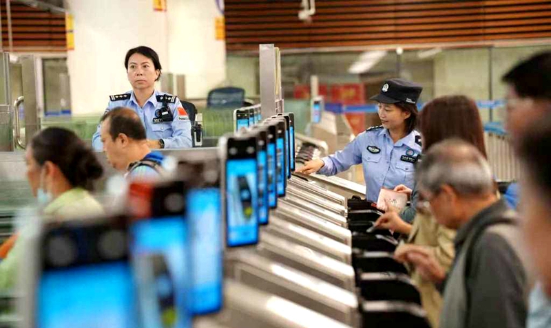 皇岗边检站民警指导首次经福田口岸智能快捷通道入境香港旅客“刷脸”丝滑通关。.jpg