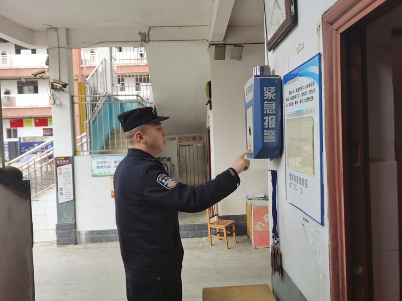 图说：民警查看学校一键式报警装置情况.jpg