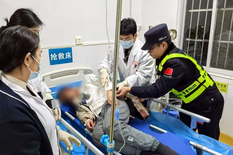 图为新兴边境派出所民警陈世浡配合医护人员救助摔伤的摩托车驾驶员，蒋丰蔚摄.jpg
