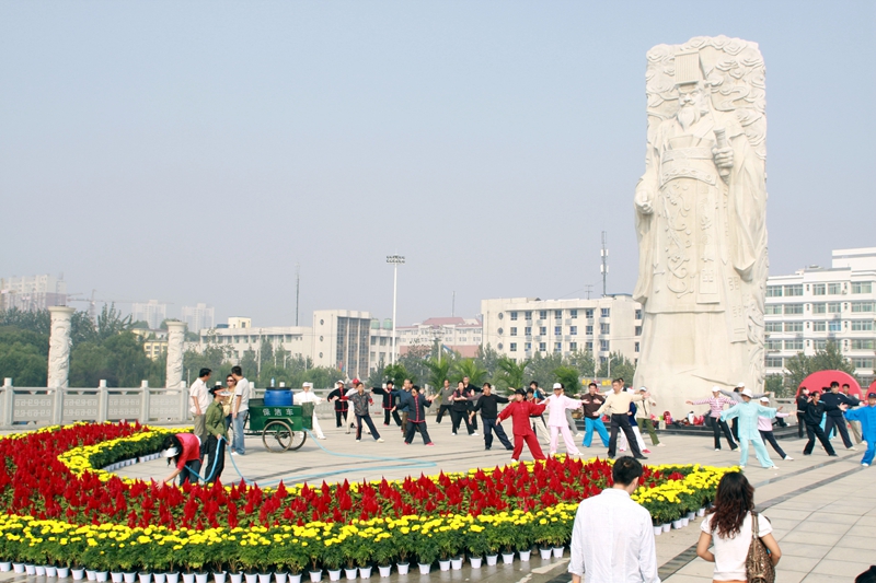 陕西省咸阳市统一广场，在秦始皇雕塑下晨练的市民在-许衙评 摄.jpg