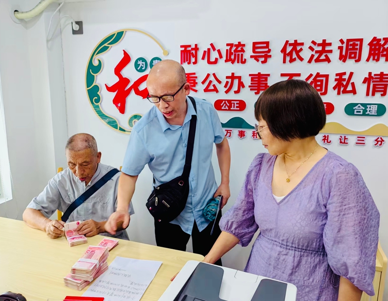 巴东县综治中心调解室里，谭文芳组织双方当事人调解，案件当场履行，实现案结事了人和.jpg