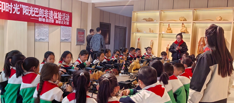 小学生在新疆塔城额敏县榆柳巷葫芦烙画研学基地参加非遗体验活动.jpg