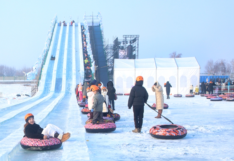1月1日，在新疆生产建设兵团第六师五家渠市青格达湖国家级旅游度假区，游客正在体验冰滑梯项目。  魏新江 摄.jpg