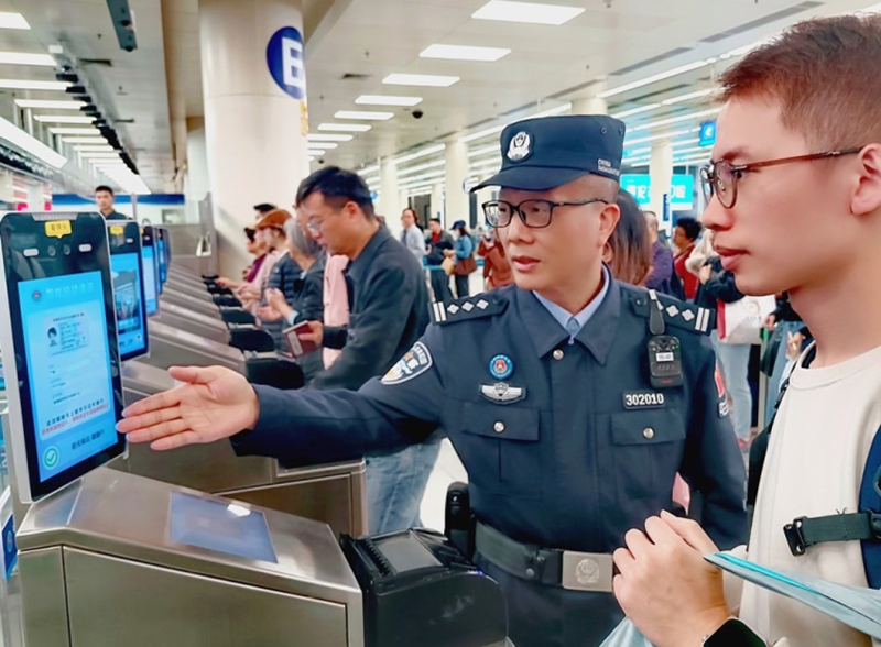 皇岗边检站民警宗全生在福田口岸出境大厅智能快捷通道引导旅客正确刷脸通关1.jpg