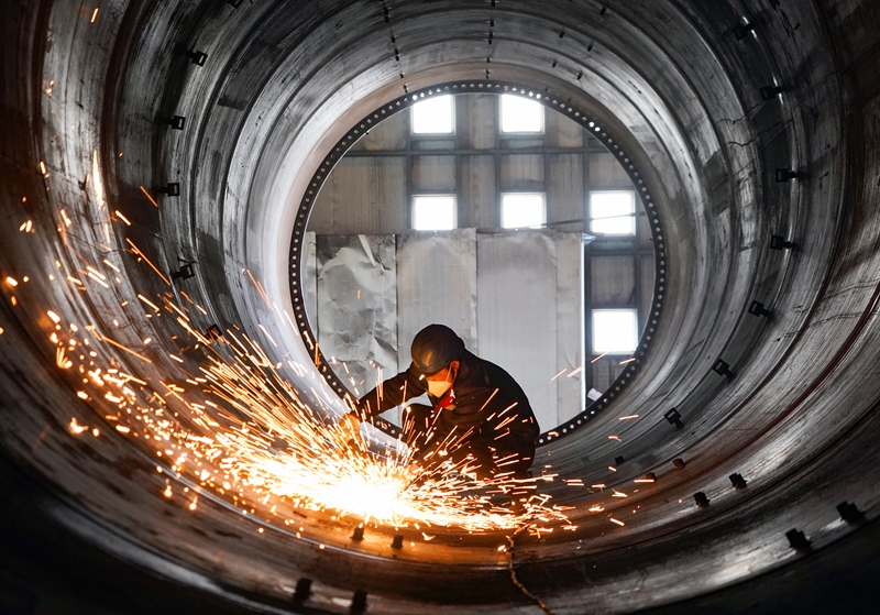 在位于贵州威宁经济开发区的贵州保龙设备制造有限公司风电塔筒生产车间，工人在对焊接好的塔筒进行焊接口打磨。（赵庆能 摄）.jpg